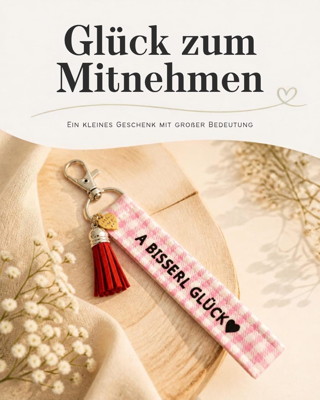 Schlüsselanhänger «A bisserl Glück» in Rosa Karo mit roter Quaste